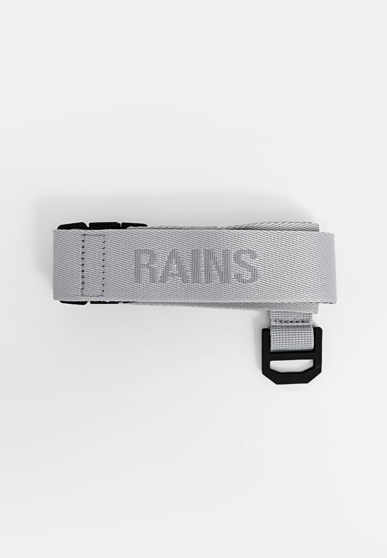 Correa de nailon gris con herrajes negros ajustables; cuenta con el logo en relieve de "RAINS"; diseño plano con una textura duradera.