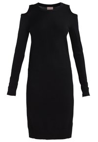 Robe en maille noire à manches longues avec découpes aux épaules et col rond, longueur au genou et silhouette ajustée.