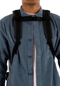 Μπλε πουκάμισο από κορντούρα με πατιλέτα κουμπιών και τσέπη στο στήθος, φορεμένο με μαύρους ρυθμιζόμενους ιμάντες στους ώμους. Μαλακή υφή και εφαρμοστή γραμμή.
