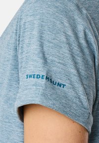 Blauwe heidelook korte mouw shirt met een zachte textuur. Heeft een contrasterend blauw "SWEDEMOUNT" logo op de mouw.