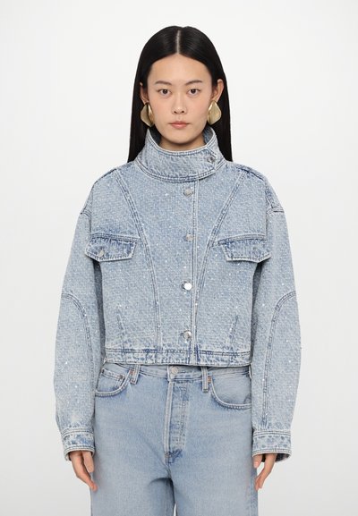Giacca di jeans cropped in blu chiaro con un design strutturato, due tasche sul petto, collo alto e decorazioni lucide sul tessuto.