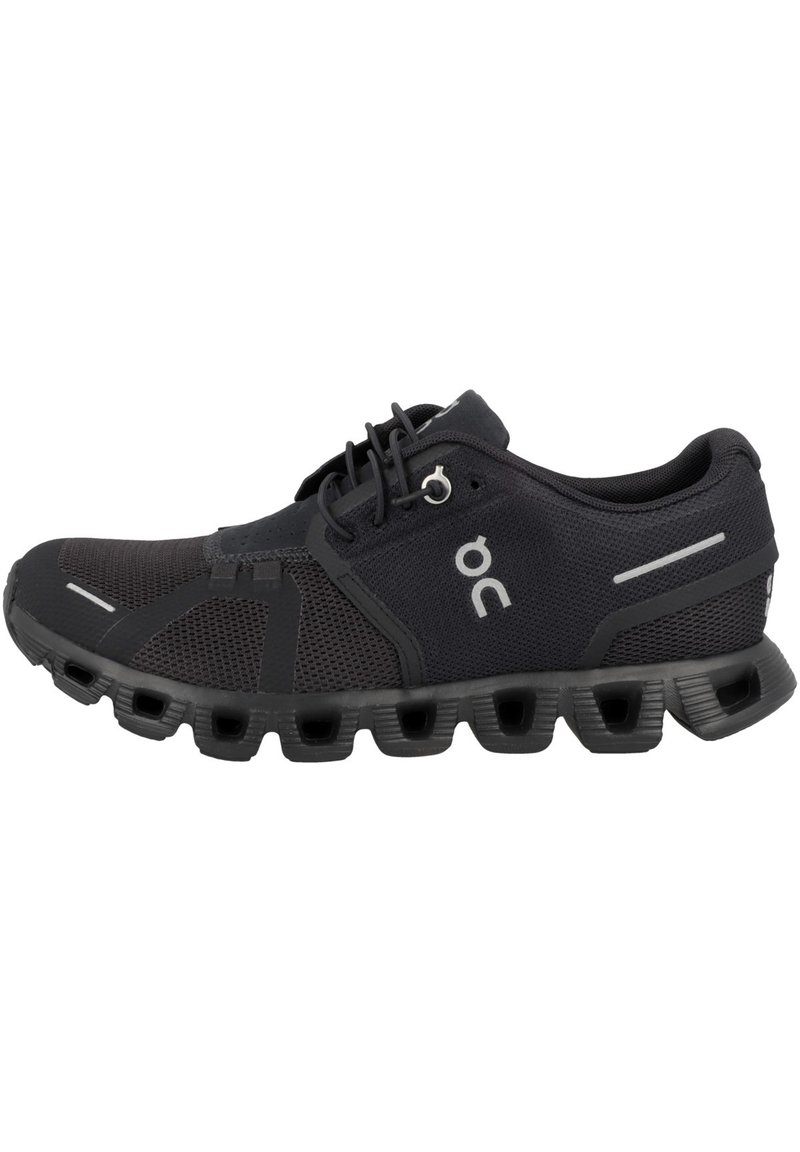 Czarne buty sportowe z oddychającej siateczki, gumowa podeszwa z okrągłymi wycięciami i odblaskowymi akcentami po bokach.