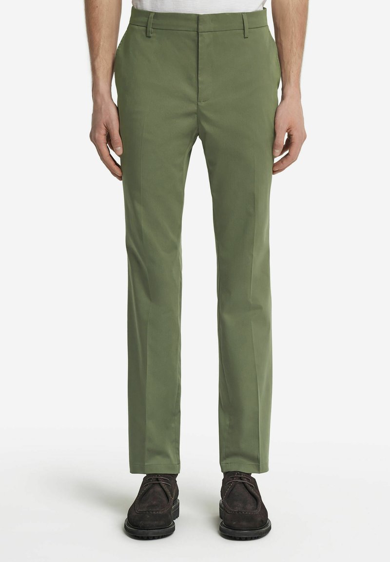 Gröna slim-fit-byxor i lätt tyg, med slät framsida, sidofickor och ren fåll, stylad med mörka snörskor.