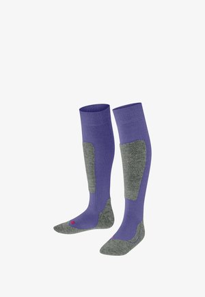 Calze viola al ginocchio con sezioni imbottite grigie, progettate per comfort e supporto durante le attività all'aperto, esposte in posizione verticale su uno sfondo bianco.