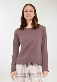 Długi rękaw top w mauve'owym dzianinie z okrągłym dekoltem i nierównym hemem, z falistymi brzegami i wiązaniem na dole.