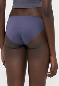 Paarse hipsterondergoed gemaakt van een gladde stof, met een medium taille en minimale stikdetails voor een naadloze uitstraling.