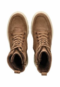 Botas de tobillo de ante marrón con diseño de cordones, forro suave y acentos texturizados. Presentan una suela de color claro en contraste y cremalleras laterales.