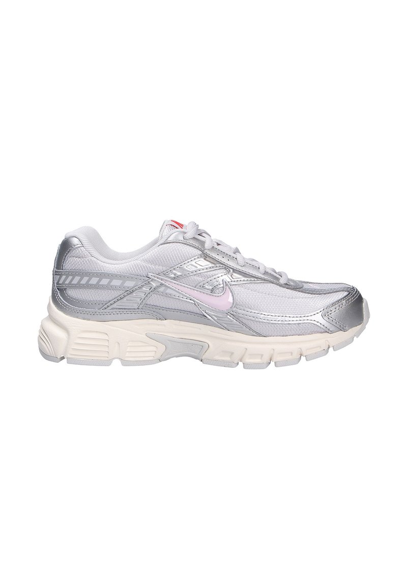 Zapatilla de running plateada con materiales de malla y sintéticos, con un upper texturizado, un swoosh de acento rosa y una suela blanca gruesa.