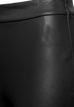 Schwarze Hosen aus Kunstleder mit glatter Textur. Verfügen über einen hohen Bund und einen seitlichen Reißverschluss als Verschluss. Dünne vertikale Steppnähte als Detail.