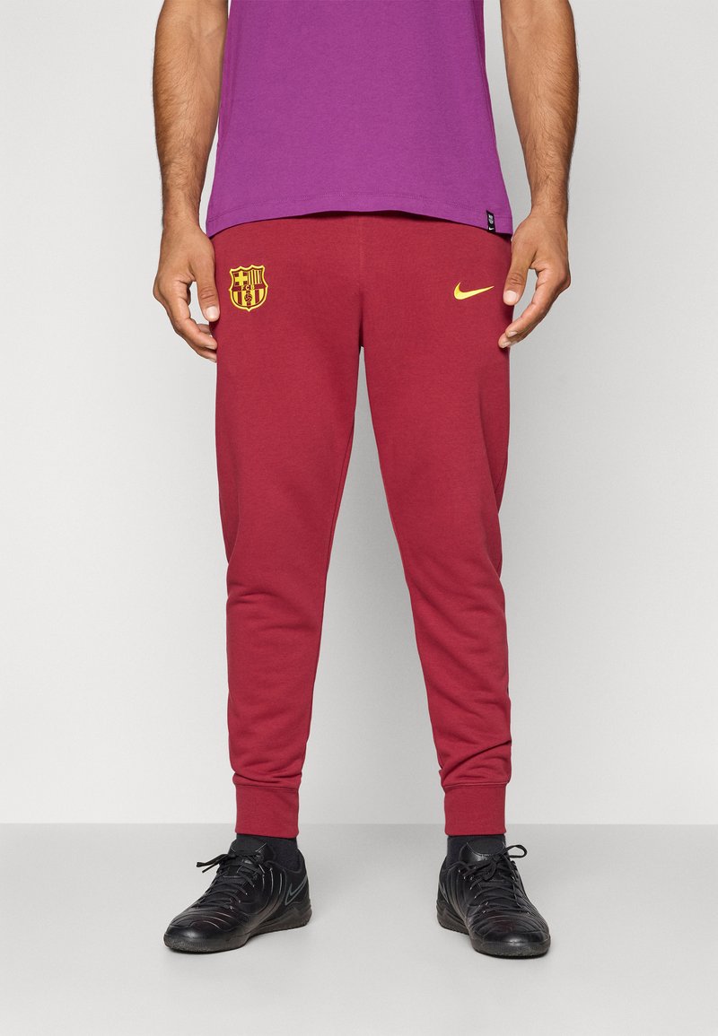 Bordo sporta bikses ar zelta Nike logotipu un FC Barcelona emblemu. Piedāvā slaidu piegriezi un ribotas aproces drošai izskatam.