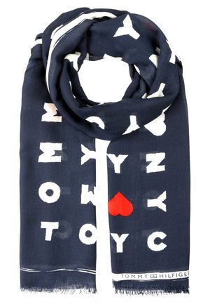 Granatowy szalik z białymi literami w blokowym kroju, które tworzą słowa „Tommy”, „NYC” oraz czerwone serce, oznakowany nazwą „Tommy Hilfiger” na krawędzi.