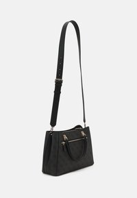 Sort håndtaske med mønster i tekstur, der har to håndtag og en aftagelig skulderrem, guldfarvet hardware og en lynlåslomme foran.