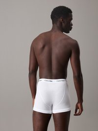 White cotton boxer briefs with a Calvin Klein logo waistband, viewed from the back, showcasing a fitted design and smooth texture.