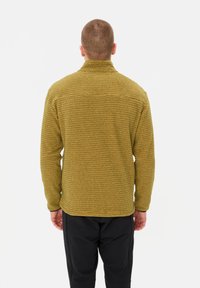 Giacca in fleece verde oliva, texture, con colletto alto e maniche lunghe, caratterizzata da una vestibilità rilassata e semplice lavorazione a cucitura nei punti di giunzione.