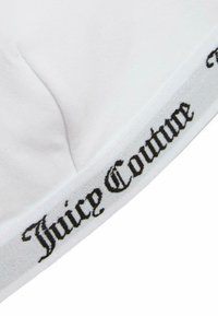 Baltos spalvos trumpas džemperis su tekstūruota juoda logotipo juosta, ant kurios užrašyta "Juicy Couture", esanti apatinėje dalyje. Minkšta medžiaga, tinka prie kūno.