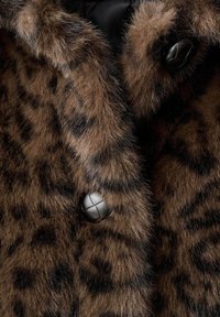 Cappotto in pelliccia sintetica marrone con macchie nere di leopardo, caratterizzato da una texture morbida e bottoni neri rotondi con un motivo a rete.