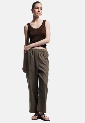 Brun ribbet tanktop, løstsiddende olivengrønne bukser, sorte flade sandaler, glat stof, afslappet og uformel design.