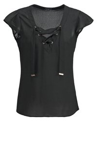 Schwarze Bluse mit kurzen Ärmeln, die einen V-Ausschnitt mit Schnürdetail, goldfarbene Ösen und einen leichten, glatten Stoff aufweist.