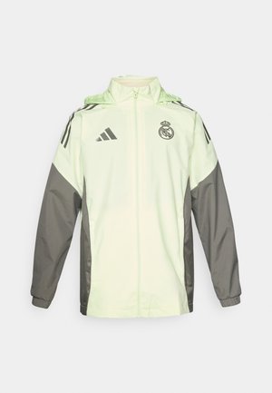 Hellgrüne und graue Jacke mit Reißverschluss, Kapuze und verstellbaren Schnüren. Verfügt über drei schwarze Streifen auf jeder Schulter und ein Logo.