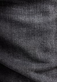 Dark grey denim fabric with a subtle texture, featuring a classic twill weave and slight sheen. No visible patterns or embellishments.