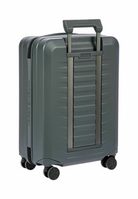 Valigia rigida grigia con design a righe, manico estraibile e quattro ruote per la mobilità. Presenta una chiusura con zip per la sicurezza.