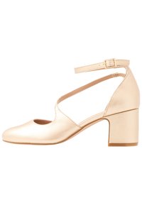 Beige Damen-Schuh mit niedrigem Blockabsatz, Knöchelriemen und Schnalle, runde Zehenpartie und Ausschnittdetail an der Seite.