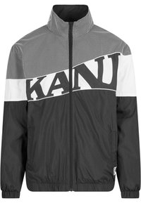 Black and white zip-up jacket featuring a mesh pattern, bold lettering, high collar, and elastic cuffs with a smooth texture.
