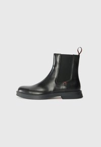 Black leather Chelsea boot with a smooth finish, elastic side panels, pull tab, and a thick rubber sole for traction and durability.