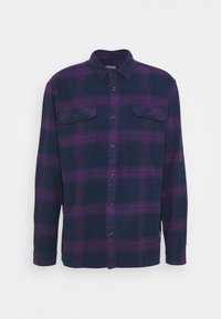 Tummansininen flanellipaita, jossa on violetti ruudullinen kuvio. Siinä on kaulus, pitkät hihat ja kaksi rintataskua painonapeilla suljettavana. Pehmeä tuntuma.