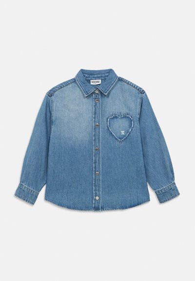 Chemise en denim bleu clair à boutons avec manches longues et un patch en forme de cœur effiloché sur la poitrine gauche.