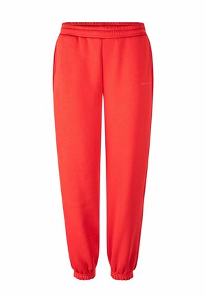 Lyse røde joggingbukser med elastisk talje og manchetter, med sidelommer og subtil branding på højre lår.