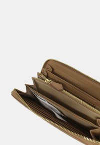 Portafoglio in pelle marrone con zip dorata e più slot per carte, sezioni per contante e una finitura testurizzata. Layout interno funzionale.
