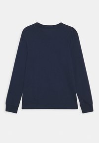 Laivastonsininen pitkähihainen t-paita pyöreällä pääntiellä ja ribatut hihansuut. Silkkinen puuvillakangas, minimalistinen muotoilu, ei kuvioita tai yksityiskohtia.