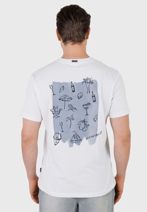 Mand iført hvid T-shirt med blåt rektangulært design, der viser sommerikoner som palmer, drikkevarer, sejlbåd, is og parasol på ryggen.