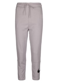 Pantalons de sudation gris clair en tissu doux, avec une taille à cordon, des jambes fuselées et un logo Nike noir sur le côté gauche.