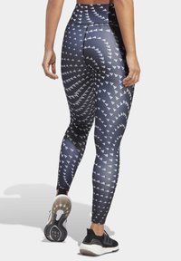 Hoggetaille leggings in navy met een wit geometrisch patroon, gemaakt van rekbaar materiaal, met een gladde textuur en platte naden.