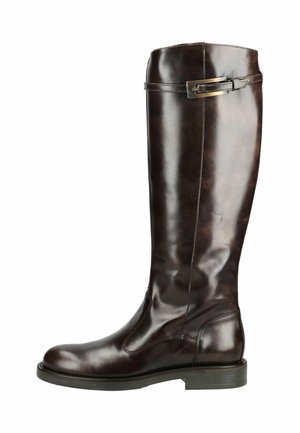 Botte haute en cuir marron foncé avec un petit talon et une sangle décorative avec boucle près du haut, vue de profil sur fond blanc.