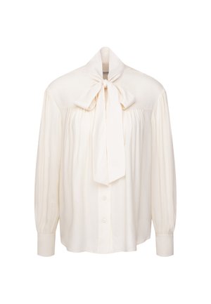Blusa crema a maniche lunghe con chiusura a bottoni, tessuto arricciato e un grande fiocco legato al collo.