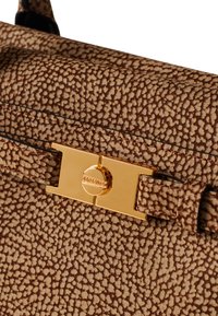 Sac à main en cuir texturé marron présentant un fermoir en métal doré avec le nom de la marque, agrémenté de coutures et d'un design structuré.