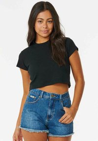 Zwarte cropped t-shirt met korte mouwen, gecombineerd met hoge blauwe denim shorts met een rafelige zoom. Eenvoudig en casual ontwerp.