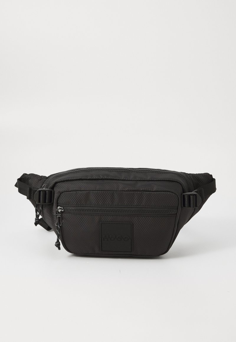 Schwarze strukturierte Bauchtasche mit zwei Reißverschlussfächern und verstellbaren Seitenträgern, ausgestattet mit einem quadratischen Patch mit eingeprägtem Markennamen.