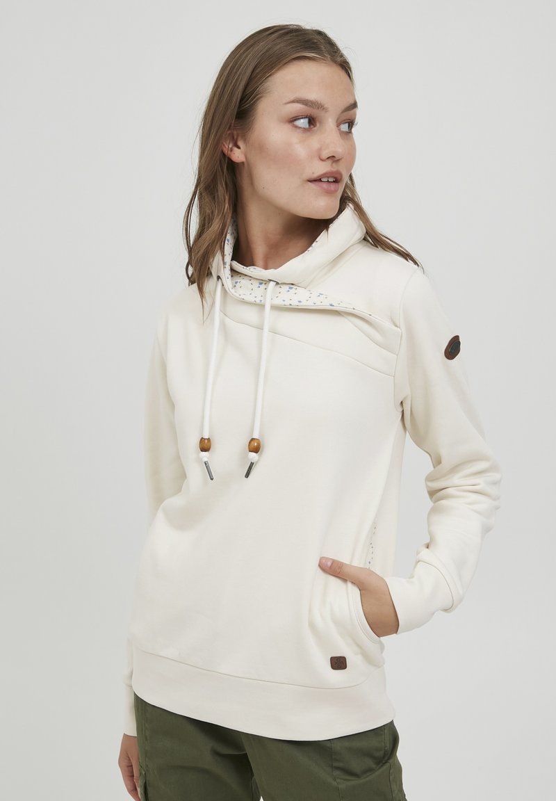 Crèmekleurige hoodie met een capuchon, koordjes met houten kralen en een decoratieve binnenvoering. Inclusief een zijzak en logo.