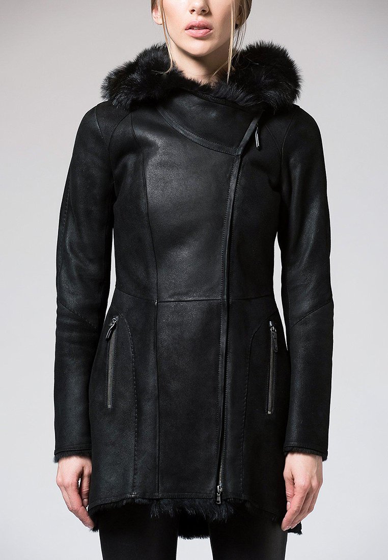 Veste en cuir noir avec capuche en fausse fourrure, fermeture éclair asymétrique, deux poches zippées à l'avant et une texture lisse avec une coupe ajustée.