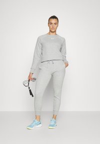 Under Armour RIVAL FLEECE - Pantaloni sportivi - mod gray light heather/white