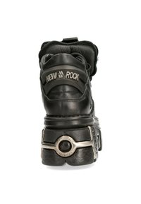 Schwarzer Leder-Hochschnittschuh mit einer dicken Sohle, Metallakzenten und einem markanten Logo an der Ferse. Texturiertes Obermaterial mit gepolstertem Kragen.