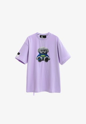 Camiseta de manga corta lila con cuello redondo y un gráfico de un oso de peluche gris con sudadera azul con capucha en la parte delantera.