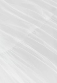 Tissu blanc avec des plis froncés créant de douces plis verticals et une texture sur toute la surface.