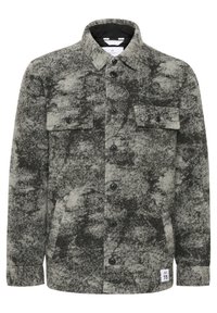 Szaro-czarny, marmurkowy wełniany żakiet zapinany na guziki z kołnierzem, dwoma kieszeniami na klatce piersiowej z klapami i guzikami oraz małą białą naszywką na dole.