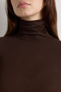 Hnědý rolák z hladké látky, s přiléhavým střihem a nařaseným detailem u výstřihu. Detailní pohled zvýrazňující texturu.