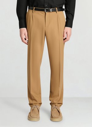 Pantalon beige sur mesure avec une texture lisse, des plis devant et une coupe légèrement fuselée, associé à une ceinture en cuir noire.